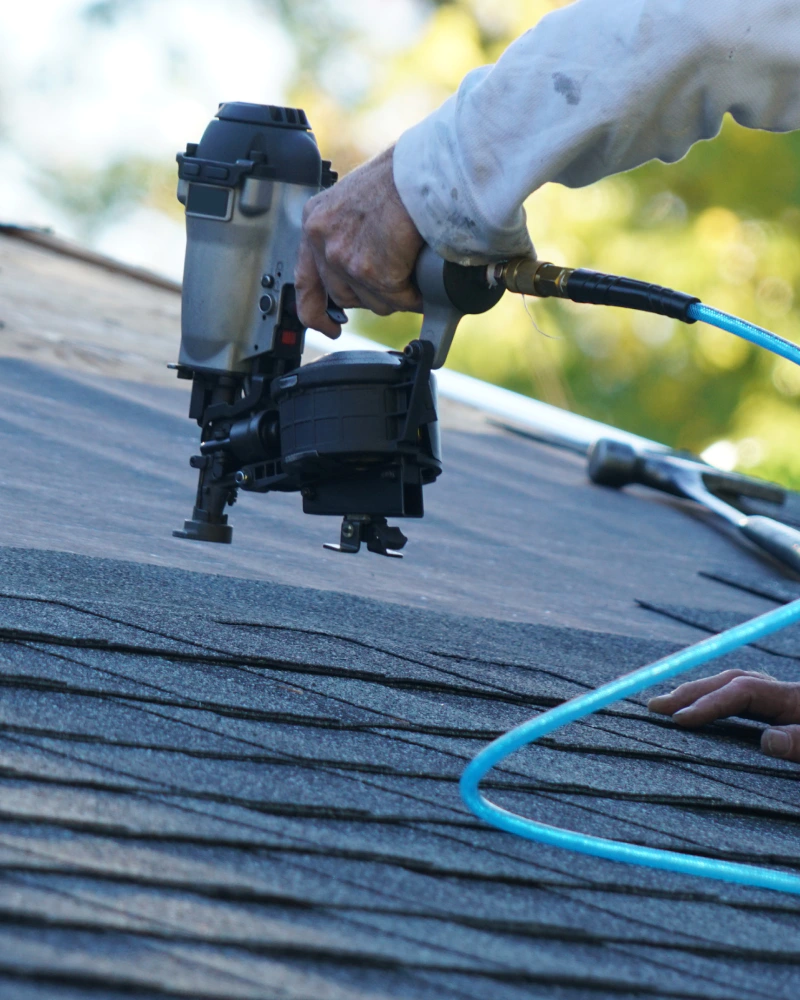 close up of a nail gun during a roof repair kansas city mo